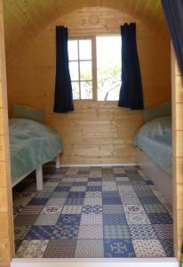 a room with two beds in a log cabin at B2B Campingpods Volkach in Volkach