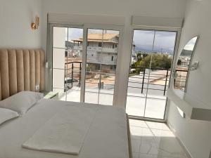 um quarto com uma cama e vista para uma varanda em Vila SUN 2E em Ksamil