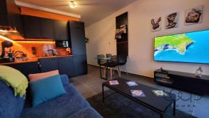 a living room with a blue couch and a large screen television at Brand New - Close To Sea - Free Wi-Fi - Super Cool - Terrace - Fully Air-conditioned - Sleeps 4 in St. Paul's Bay
