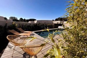 a patio with two chairs and a swimming pool at Villa piscine à 1km plage proche porto vecchio in Lecci
