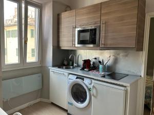eine Küche mit einer Waschmaschine und einer Mikrowelle in der Unterkunft Appartamento Toscanella in Florenz