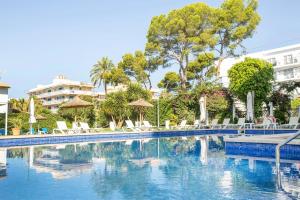 a swimming pool with chairs and umbrellas at Hotel Foners in Playa de Palma