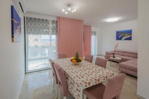 uma sala de jantar com uma mesa com cadeiras e um sofá em Villa Gizella em Sveti Filip i Jakov