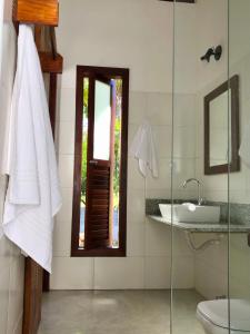 a bathroom with a sink and a glass shower at Chalés do Maestro in Ilha de Boipeba +43 photos