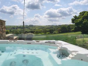 a hot tub in a backyard with a view of a field at Green Barn in Sheffield