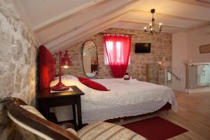 a bedroom with a bed with a red curtain at Bed & Breakfast Vila Baguc in Split