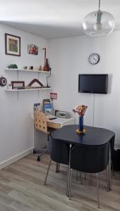 Zimmer mit einem Tisch, Stühlen und einem Schreibtisch in der Unterkunft La Victoire in Granville