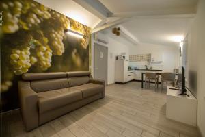 salon z kanapą i obrazem winogron w obiekcie CityU - Grazioli 27 Trento Centro con parcheggio privato w Trydencie
