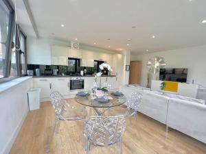 a kitchen and living room with a table and chairs at Beautifully Presented Apartment in London