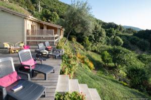 eine Terrasse mit Stühlen und Tischen auf einem Haus in der Unterkunft Les Terrasses de Scaglioli in Villanova