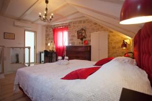 a bedroom with a large white bed with red pillows at Bed & Breakfast Vila Baguc in Split