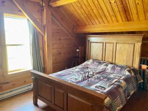 una camera con un letto in una cabina di legno di Spacious Salmon River Waterfront Lodge for 6 a Altmar