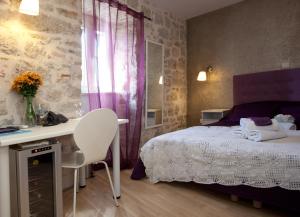 a bedroom with a bed and a desk and a window at Bed & Breakfast Vila Baguc in Split