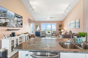 a kitchen with a sink and a living room at Gratitude Island in Navarre