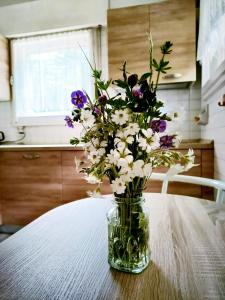 um vaso cheio de flores sentado numa mesa em Il Terrazzo Sulle Dolomiti em Cibiana