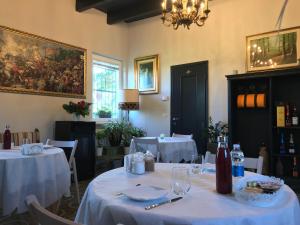 un comedor con 2 mesas con mantel blanco en B&B Villa Prestigio, en Novi Ligure