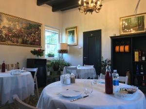 a dining room with two tables with white table cloth at B&B Villa Prestigio in Novi Ligure