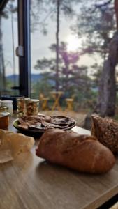 a table with two plates of bread and a window at La calade in Bargème