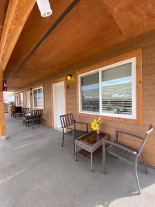 une véranda avec des chaises, une table et une fenêtre dans l'établissement Rhodopa Lodge at Yellowstone, à Gardiner