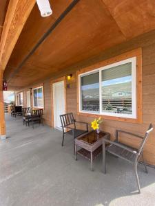 porche con sillas, mesa y ventana en Rhodopa Lodge at Yellowstone, en Gardiner