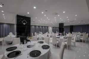 a dining room with white tables and white chairs at Hotel Ancora in Pontecagnano +86 photos