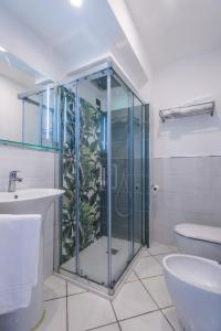 bagno con doccia in vetro e servizi igienici di Hotel Ancora a Pontecagnano