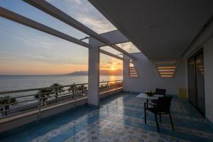 a balcony with a view of the ocean at sunset at Hotel Ancora in Pontecagnano