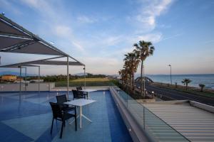 a balcony with a table and chairs and the ocean at Hotel Ancora in Pontecagnano