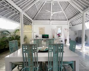 comedor con mesa blanca y sillas en Dreams Villa - Double Six Beach en Seminyak