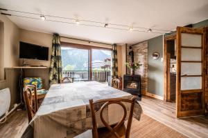 a dining room with a table and chairs and a fireplace at Chalet Perce Neige in Châtel