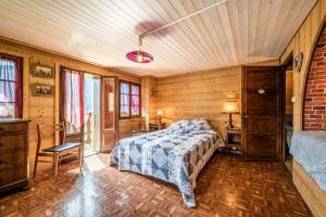a bedroom with a bed in a room with wooden walls at Chalet Perce Neige in Châtel
