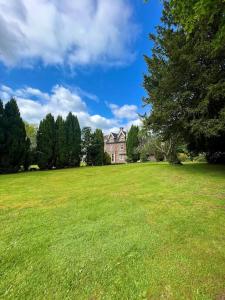 a large green field with a house in the background at The Beeches - Entire Mansion in Bristol