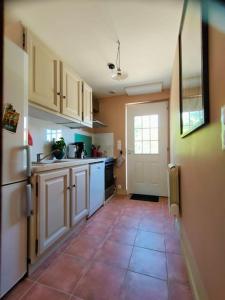 a kitchen with white cabinets and a tile floor at Dolce Vita en Provence in Châteaurenard