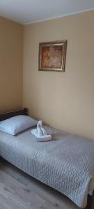 a bedroom with a bed with a towel on it at Willa u MARIANE in Przeźmierowo