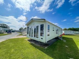 a white tiny house sitting on the grass at Beautiful Caravan At Highfield Grange Holiday Park In Essex Ref 26687p in Clacton-on-Sea