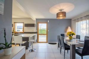 eine Küche und ein Esszimmer mit Tisch und Stühlen in der Unterkunft MAISON MODERNE PROCHE DES BELLES PLAGES in Crach