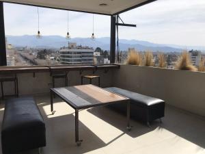 a table and bench on a balcony with a view at Hotel Internacional in Mendoza