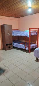 a room with two bunk beds and a wooden cabinet at Alojamiento El Remanso in Puerto Iguazú