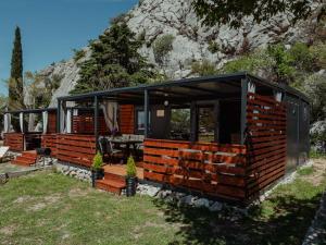 a house built out of wooden logs in the grass at Mobile home Aurora in Sveti Juraj