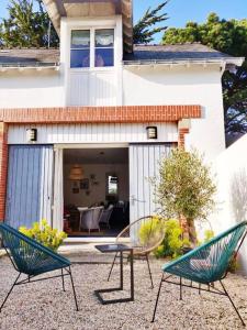 dos sillas y una mesa frente a una casa en Bourg de Batz, en Batz-sur-Mer