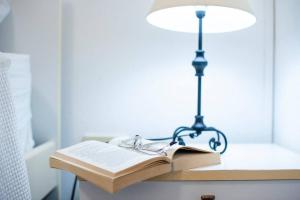 a lamp and an open book on a table with a book at [Torregrande]APT.3 - Vicino al mare - Free Wi-Fi in Torre Grande