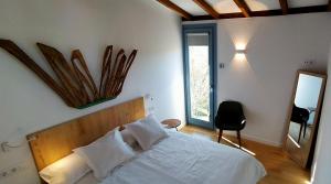 1 dormitorio con cama blanca y ventana en O Souto da Aldea, en Parada del Sil