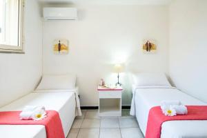 two beds in a room with white walls and a red blanket at [Torregrande]APT.3 - Vicino al mare - Free Wi-Fi in Torre Grande