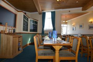 a dining room with a wooden table and chairs at The Golf Hotel in Crail