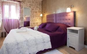 a bedroom with a purple bed with a white blanket at Bed & Breakfast Vila Baguc in Split