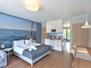 a bedroom with a bed and a kitchen with the ocean at Zefiro Chmielna in Gdańsk