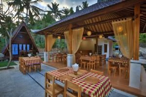 a restaurant with tables and chairs and a pavilion at Mahaloka Valley Nusa Penida in Nusa Penida