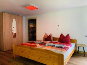 um quarto com uma grande cama de madeira com almofadas vermelhas em Naturhof Kluge em Saupsdorf
