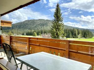 uma varanda com uma mesa e vista para uma montanha em Chalet Cristall em Leutasch