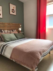 a bedroom with a large bed with a red curtain at Eleni appart 4p à Richelieu in Chaveignes